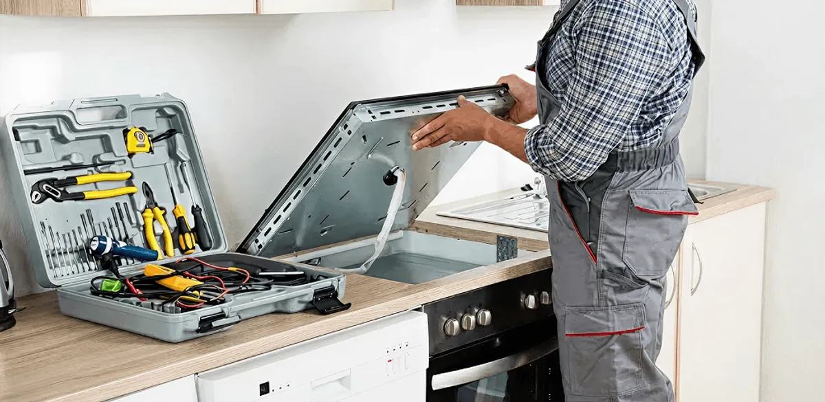 Handyman repairing a cooktop and checking wiring connections in Rockford, IL